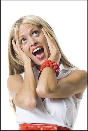 Close-up of a young woman looking surprised with her head in her hands Stock Photo - Premium Royalty-Free, Code: 640-01359269