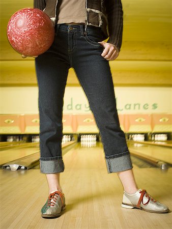 Low section view of a teenage girl standing at a bowling alley Stock Photo - Premium Royalty-Free, Code: 640-01359366