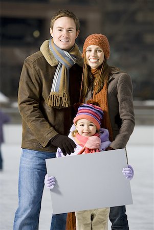 simsearch:640-02772458,k - Man and woman with girl holding blank sign outdoors in winter Stock Photo - Premium Royalty-Free, Code: 640-01359383