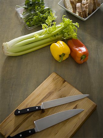 Cutting board with knives and vegetables with sliced bread Stock Photo - Premium Royalty-Free, Code: 640-01359537
