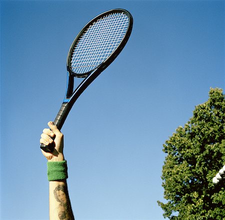 raquette de tennis - Vue d'angle faible d'un jeune homme tenant une raquette de tennis Photographie de stock - Premium Libres de Droits, Code: 640-01359611