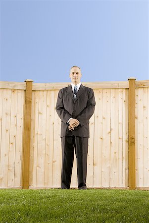 Low angle view of a businessman standing in front of a wall Stock Photo - Premium Royalty-Free, Code: 640-01350134