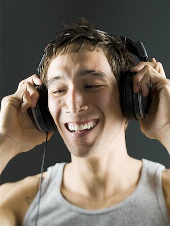 Close-up of a young man with headphones on Stock Photo - Premium Royalty-Free, Code: 640-01350385