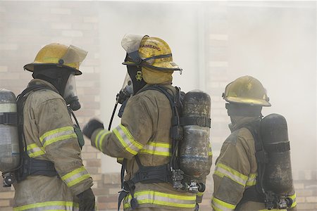 disaster and rescue - Three firefighters in firefighting gear Stock Photo - Premium Royalty-Free, Code: 640-01350401