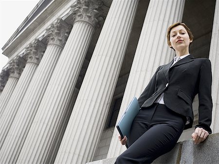 Low angle view of a female lawyer standing in front of a courthouse Stock Photo - Premium Royalty-Free, Code: 640-01350426