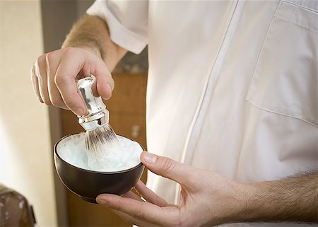 Vue en coupe milieu de mélange crème à raser avec un pinceau dans un bol à la main de l'homme Photographie de stock - Premium Libres de Droits, Code: 640-01350662