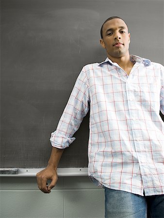 African American male student leaning against chalkboard Stock Photo - Premium Royalty-Free, Code: 640-01350673