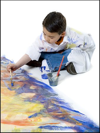 High angle view of a boy painting on the floor Stock Photo - Premium Royalty-Free, Code: 640-01350695