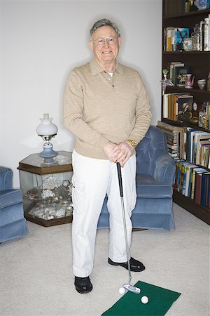 Portrait of a senior man holding a golf club Stock Photo - Premium Royalty-Free, Code: 640-01350788