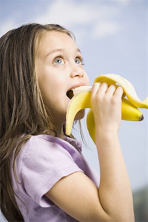 Young girl eating banana Stock Photo - Premium Royalty-Free, Code: 640-01350991