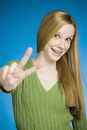retainer - Girl making peace sign smiling Stock Photo - Premium Royalty-Free, Code: 640-01351105