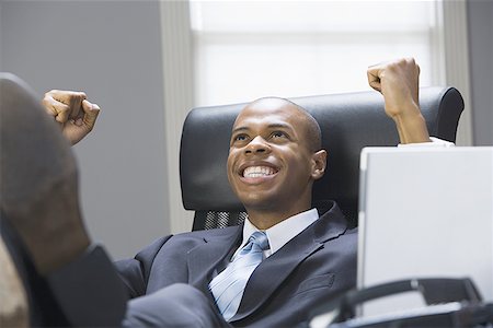 Close-up of a businessman looking up and clenching fists Stock Photo - Premium Royalty-Free, Code: 640-01351115