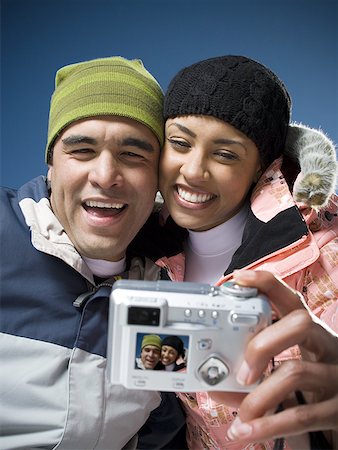 simsearch:640-01356469,k - Low angle view of a young woman and an adult man looking at a digital camera Stock Photo - Premium Royalty-Free, Code: 640-01351112