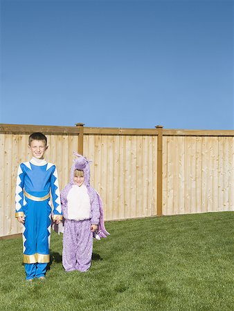 family of superheroes - Portrait of brother with his sister in costumes and standing in the backyard of their house Stock Photo - Premium Royalty-Free, Code: 640-01351133