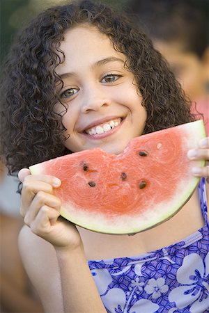 simsearch:640-01365502,k - Portrait d'une jeune fille tenant un sourire de melon d'eau Photographie de stock - Premium Libres de Droits, Code: 640-01351175