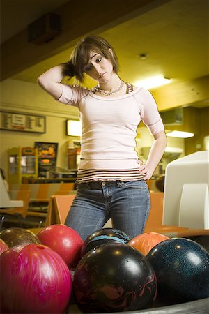 simsearch:640-03265586,k - Low angle view of a teenage girl looking at bowling balls and scratching her head Stock Photo - Premium Royalty-Free, Code: 640-01351236