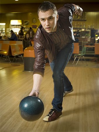 Young man bowling in a bowling alley Stock Photo - Premium Royalty-Free, Code: 640-01351308