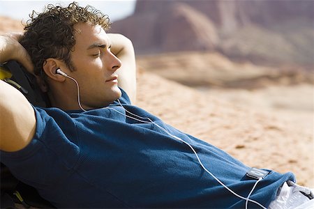 etiquette men - Close-up of a young man lying on his back and listening to an MP3 Player Stock Photo - Premium Royalty-Free, Code: 640-01351473