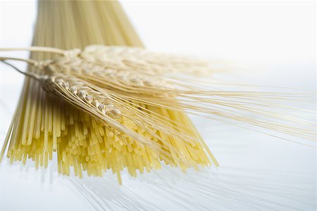 Close-up of wheat stalks and uncooked spaghetti Stock Photo - Premium Royalty-Free, Code: 640-01351547