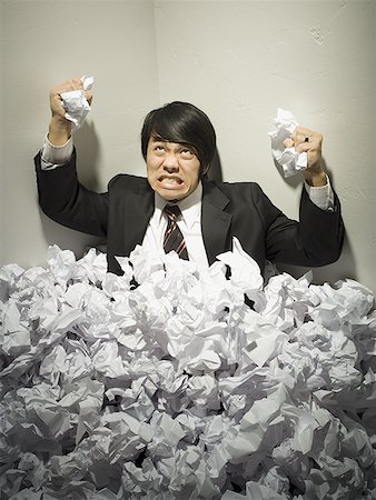 Businessman buried in mountain of crumpled papers Stock Photo - Premium Royalty-Free, Code: 640-01351569