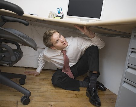 hiding under desk office worker