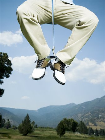 simsearch:640-01356786,k - Low section view of a man jumping in air with a golf club Foto de stock - Sin royalties Premium, Código: 640-01351679