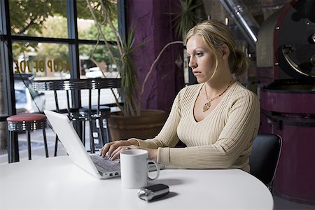 simsearch:640-01348908,k - Young woman using a laptop in a café Foto de stock - Royalty Free Premium, Número: 640-01351684