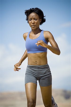 Low angle view of a young woman jogging Stock Photo - Premium Royalty-Free, Code: 640-01351714