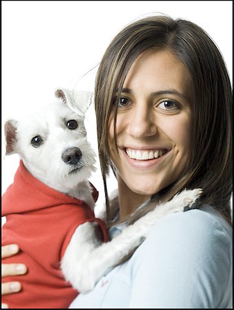 Portrait of a young woman holding a dog in her arms and smiling Stock Photo - Premium Royalty-Free, Code: 640-01351733