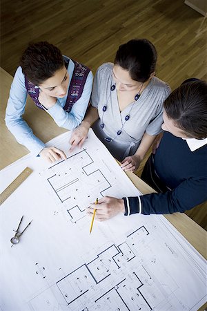 High angle view of three architects looking at blueprints Stock Photo - Premium Royalty-Free, Code: 640-01351934