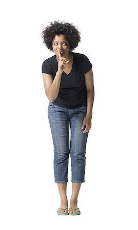 Jeune femme debout avec son doigt sur ses lèvres Photographie de stock - Premium Libres de Droits, Code: 640-01352029