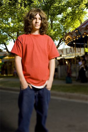 rebellious in secondary school - Low angle view of a teenage boy standing with hands in his pockets Stock Photo - Premium Royalty-Free, Code: 640-01352227