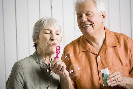 Close-up of an elderly couple blowing bubbles with a bubble wand Foto de stock - Sin royalties Premium, Código: 640-01352504