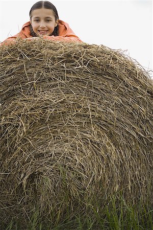 Portrait of a girl lying on a haystack Stock Photo - Premium Royalty-Free, Code: 640-01352524