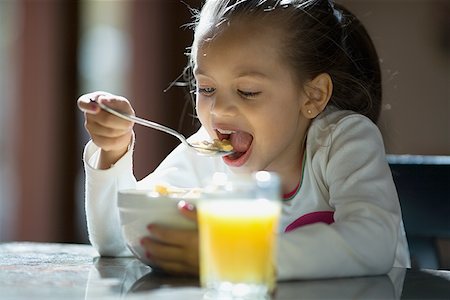 eat with cereal bowl with spoon - Close-up of a girl eating cereal Stock Photo - Premium Royalty-Free, Code: 640-01352619