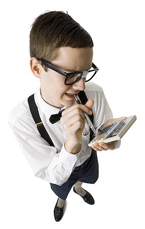 Male nerd with suspenders and tape on eyeglasses looking at calculator with pen Stock Photo - Premium Royalty-Free, Code: 640-01352726