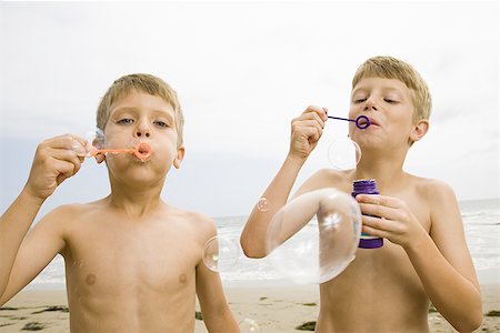 swimmer bubbles - Two boys blowing bubbles on the beach Stock Photo - Premium Royalty-Free, Code: 640-01352769