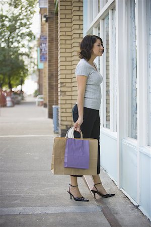 full height - Profile of an adult woman looking at a window display Stock Photo - Premium Royalty-Free, Code: 640-01352787