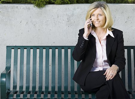 simsearch:640-01348908,k - Businesswoman sitting on a bench and talking on a mobile phone Foto de stock - Royalty Free Premium, Número: 640-01352954