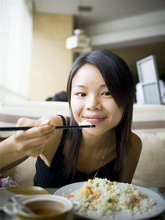 Woman eating at a Chinese food restaurant Stock Photo - Premium Royalty-Free, Code: 640-01352962