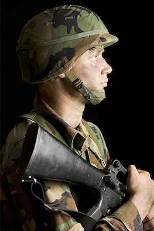 simsearch:640-01360442,k - Profil de côté d'un soldat tenant un fusil Photographie de stock - Premium Libres de Droits, Code: 640-01353069