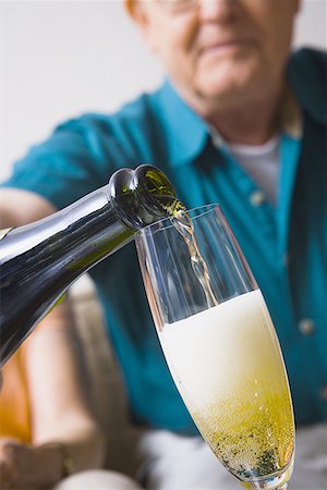 senior and saving - Low angle view of a man's hand pouring champagne into a champagne flute Foto de stock - Sin royalties Premium, Código: 640-01353151