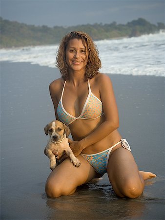 Portrait of a woman holding a dog on the beach Stock Photo - Premium Royalty-Free, Code: 640-01353194