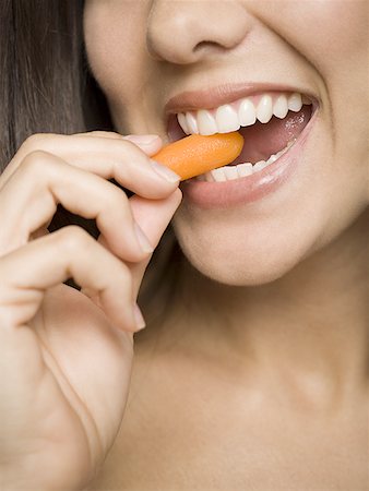 Close-up of a woman eating a carrot Stock Photo - Premium Royalty-Free, Code: 640-01353231