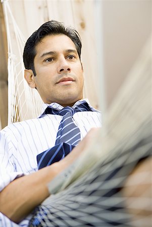 Close-up of a businessman sitting in a hammock Stock Photo - Premium Royalty-Free, Code: 640-01353282