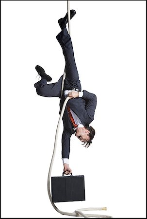 Businessman with briefcase dangling upside down from a rope Foto de stock - Sin royalties Premium, Código: 640-01353364