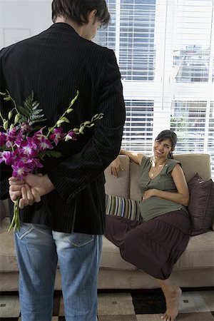 picture business woman house husband - Rear view of a man holding flowers and looking at a pregnant woman Stock Photo - Premium Royalty-Free, Code: 640-01353444