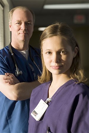 side images of dark hair nurse in uniform - Portrait of a female doctor with a male doctor standing behind her Stock Photo - Premium Royalty-Free, Code: 640-01353605