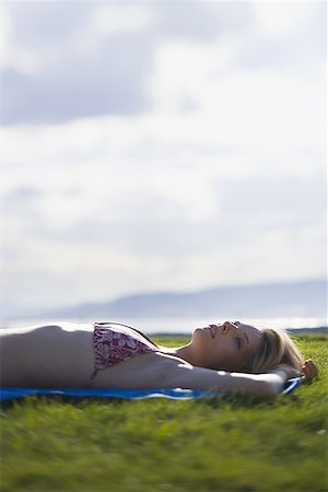 simsearch:700-00683573,k - Young woman lying down on a field Foto de stock - Royalty Free Premium, Número: 640-01353711