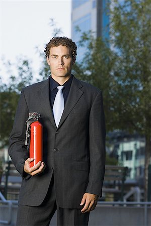 suit on fire - Portrait of a businessman holding a fire extinguisher Stock Photo - Premium Royalty-Free, Code: 640-01353766